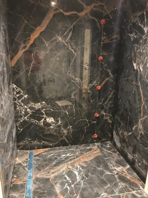 pose complète de carreaux XXL dans une salle de douche, sol et mur